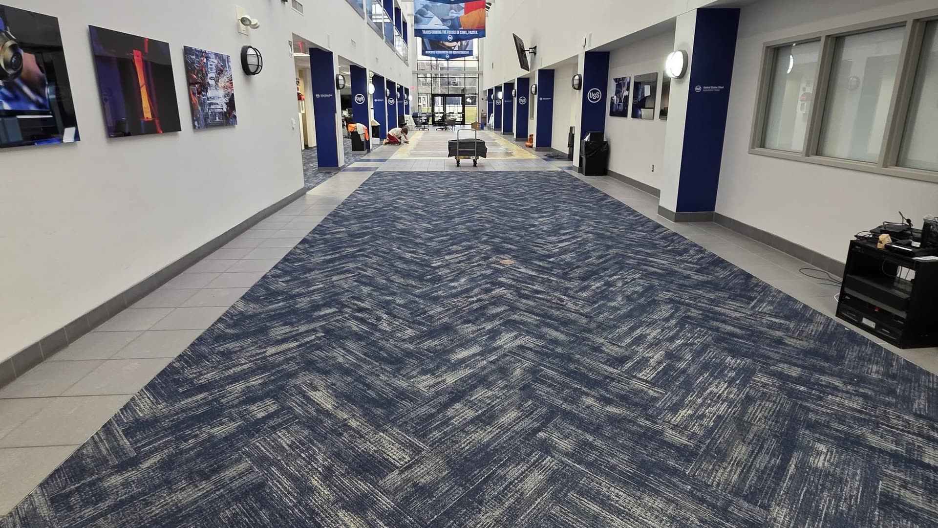 Finished herringbone carpet-plank installation in a two-story atrium