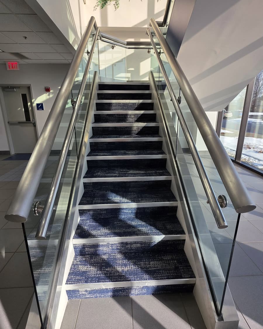 Carpeted stair treads in a glass-rail stair